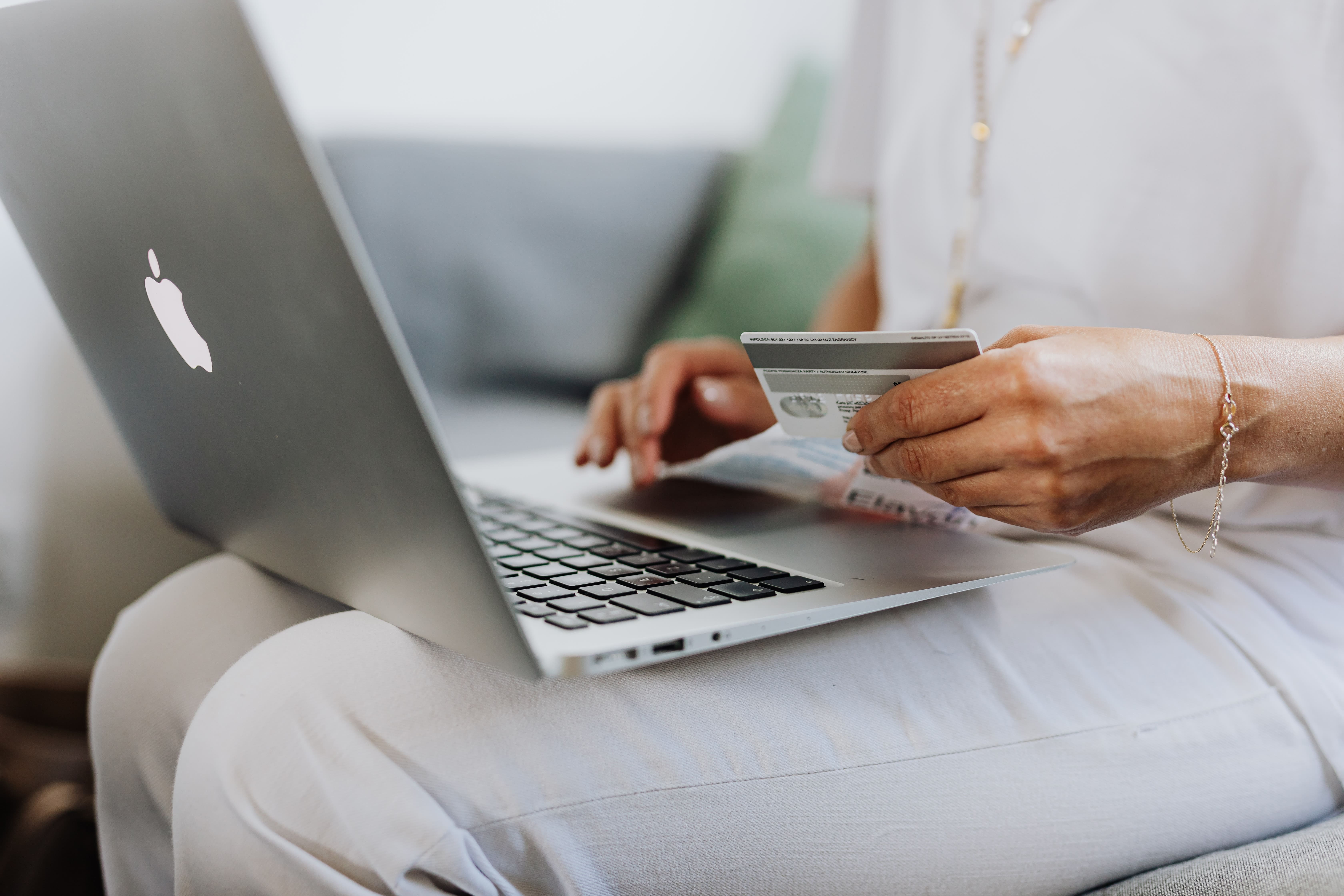 Woman online shopping on laptop with credit card out